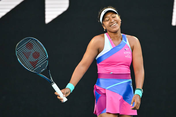 Naomi Osaka of Japan laughs after missing a shot against Madison Brengle of the United States during day three of the 2022 Australian Open at...