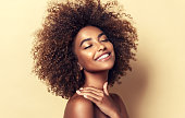 Natural Afro hair. Wide toothy smile and expression of pleasure on the face of young brown skinned woman. Afro beauty.