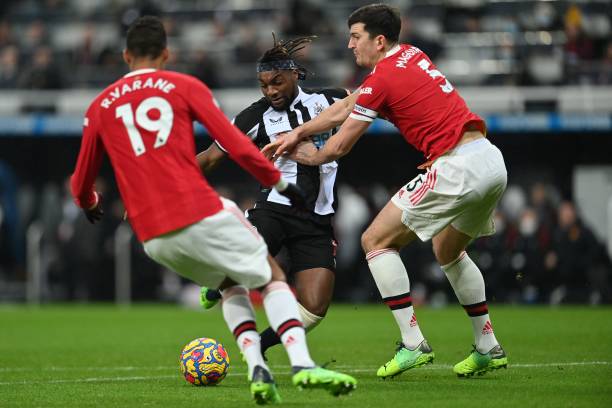 Newcastle United's French midfielder Allan Saint-Maximin shoots past Manchester United's French defender Raphael Varane and Manchester United's...
