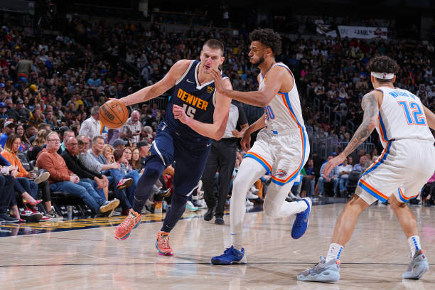 Nikola Jokic of the Denver Nuggets dribbles the ball during the game against the Oklahoma City Thunder on March 26, 2022 at the Ball Arena in Denver,...