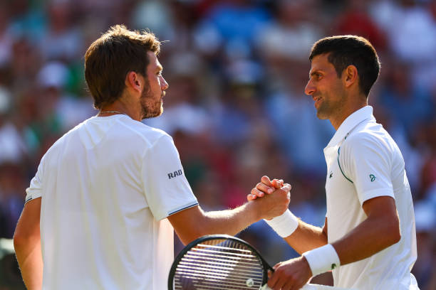 Novak Djokovic of Serbia cis congratulated by Cameron Norrie of Great Britain after his victory in the semi-finals of the men's singles during day...