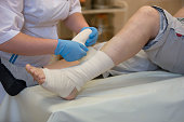 Nurse bandages a patient's leg