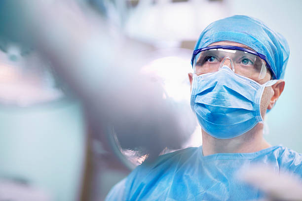 nurse giving tools to surgeon in operating room - cirurgia  - fotografias e filmes do acervo