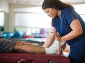 Occupational therapist holding leg and foot of patient