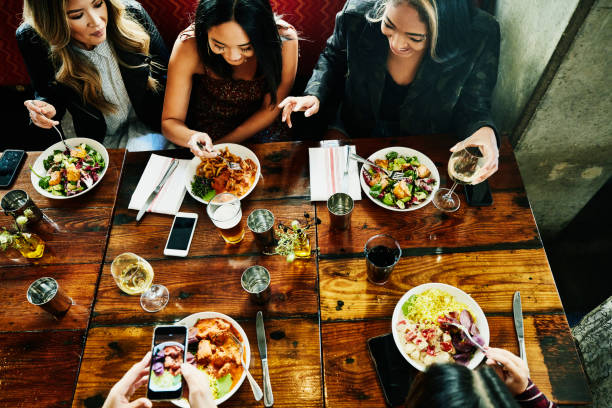 overhead view of smiling female friends sharing lunch in restaurant picture