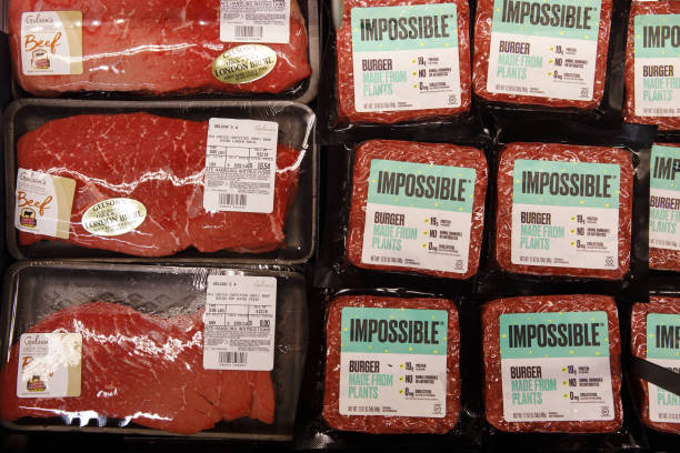 Packages of beef are displayed for sale alongside Impossible Burger plant based meat during the Impossible Foods Inc. Grocery store product launch in...