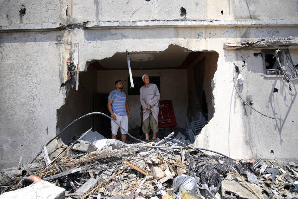 Palestinians inspect the ruins of a collapsed building destroyed by an Israeli air strike in Gaza City, on August 6, 2022. - Israel hit Gaza with air...