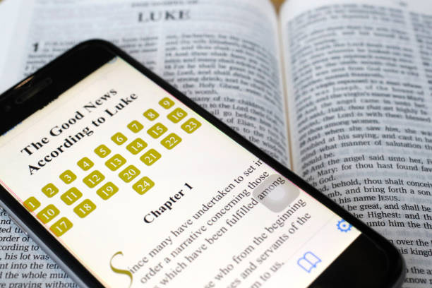 paper bible and digital bible app on smartphone.  the new testament. gospel. luke. - a cellphone with bible app stock pictures, royalty-free photos & images