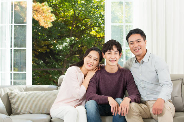 parents and son talking on sofa - asian couple with son stock pictures, royalty-free photos & images