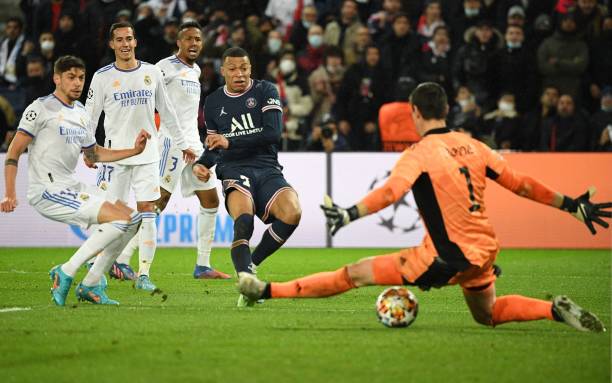 Paris Saint-Germain's French forward Kylian Mbappe shoots and scores a goal during the UEFA Champions League round of 16 first leg football match...