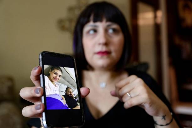 Patricia Nassif, a 29-year-old Lebanese breast cancer patient, shows her telephone screen with a photograph of herself at the hospital accompanied by...