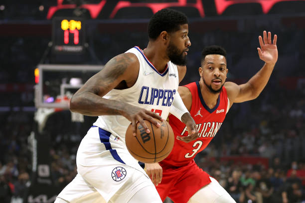 Paul George of the LA Clippers dribbles past the defense of CJ McCollum of the New Orleans Pelicans during the first half of a game at Crypto.com...