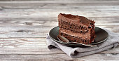 A peace of vegan chocolate davil cake on grey wooden background