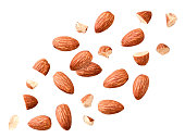 Peeled almonds whole and pieces flying on a white. Isolated