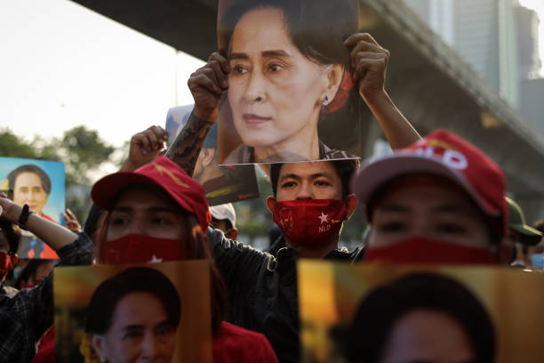 People hold up images of Myanmar's de-facto leader Aung San Suu Kyi at a protest outside Maynmar's embassy on February 01, 2021 in Bangkok, Thailand....