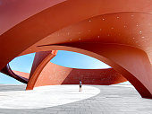 A person in a red curved abstract architectural space, 3D rendering