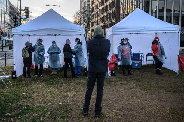 Person waits to get tested at a Covid-19 testing site in Washington DC, on December 22, 2021. - Days out from Christmas, Americans are facing long...