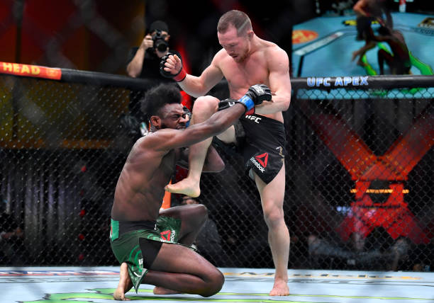 Petr Yan of Russia delivers an illegal knee against Aljamain Sterling in their UFC bantamweight championship fight during the UFC 259 event at UFC...