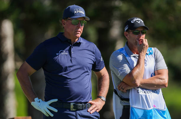 Phil Mickelson of the United States waits with caddie Tim Mickelson on the second tee during the third round of the Sentry Tournament of Champions at...