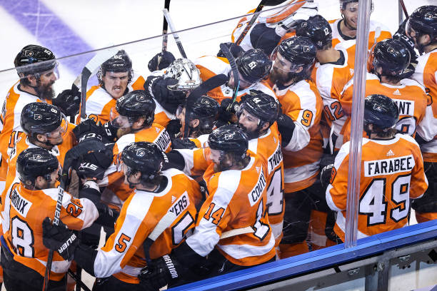 Philippe Myers of the Philadelphia Flyers is congratulated by his teammates after scoring the game-winning goal during the first overtime period to...