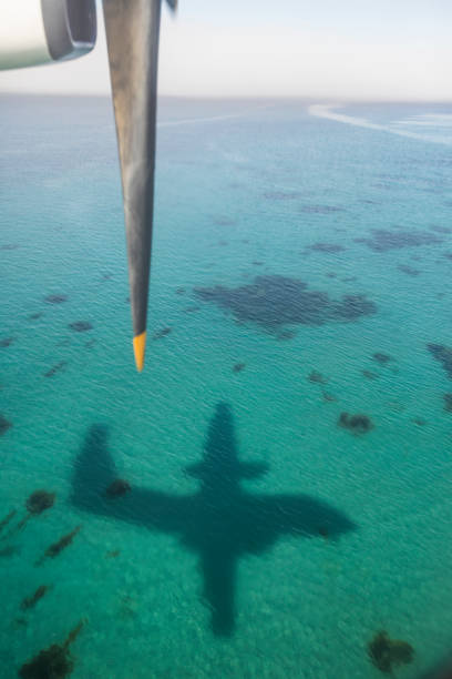 Plane shadow reflected on turquoise water,