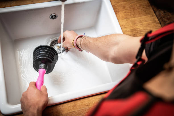 plumber using a pipe plunger to fix kitchen sinks - sewer house - fotografias e filmes do acervo
