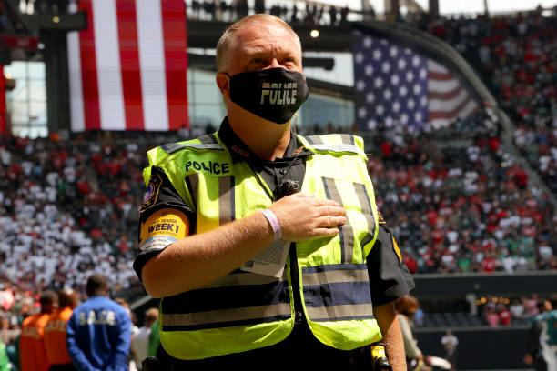 Police officer stands inside Mercedes-Benz Stadium during the national anthem prior to the game between the Atlanta Falcons and the Philadelphia...