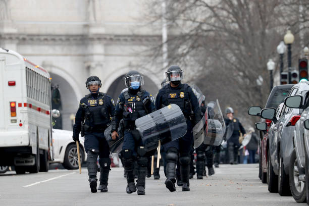Police officers in riot gear walks towards the U.S. Capitol as protesters enter the building on January 06, 2021 in Washington, DC. Trump supporters...