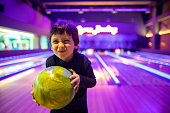 Portrait Cute child with ball in bowling club