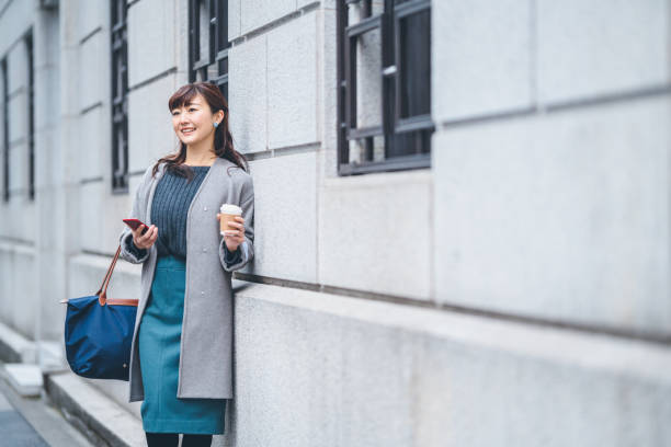 portrait of businesswoman in street while holding coffee - winter skirt stock pictures, royalty-free photos & images