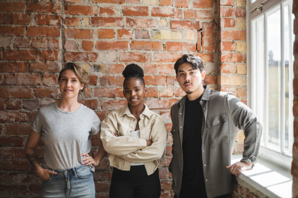 portrait of male and female colleague standing in office - software developer stock pictures, royalty-free photos & images