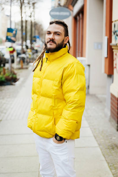 portrait of man wearing yellow jacket - puffer jacket stock pictures, royalty-free photos & images