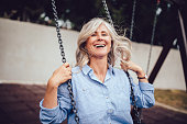 Portrait of mature woman with gray hair sitting on swing