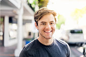 Portrait of smiling young man in city on sunny day