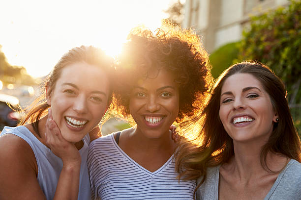 Portrait of three young adult female friends in the street