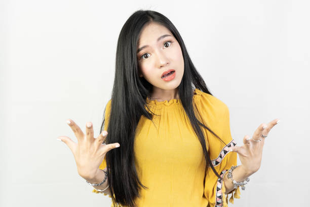 portrait of young woman posing confuse action on white background. - angry asian woman stock pictures, royalty-free photos & images