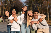Positive group of young friends having fun at public park