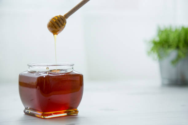 pouring honey into jar of honey picture