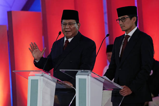 Prabowo Subianto presidential candidate left speaks while Sandiaga Uno vice presidential candidate listens during a first presidential debate in...