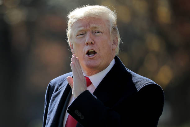 President Donald Trump shouts at journalists from across the South Lawn as he departs the White House November 29, 2017 in Washington, DC. Trump is...