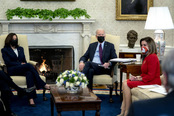 President Joe Biden, center, U.S. Vice President Kamala Harris, left, and U.S. House Speaker Nancy Pelosi, a Democrat from California, wear...
