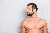 Profile side view half-faced portrait with copy space of handsome, sexy, athletic, confident, sporty, naked guy with perfect, ideal skin, isolated on gray background