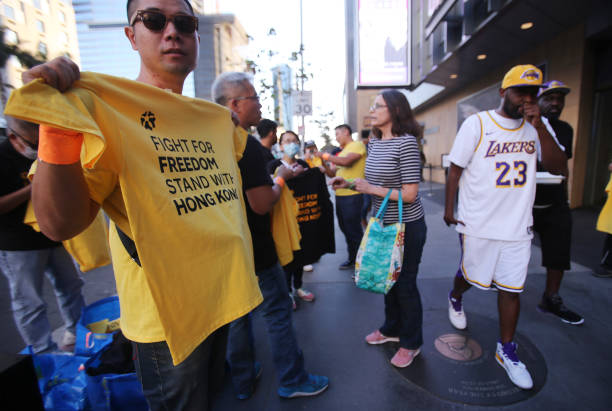 Pro-Hong Kong activist hands out t-shirts before the Los Angeles Lakers season opening game against the LA Clippers outside Staples Center on October...