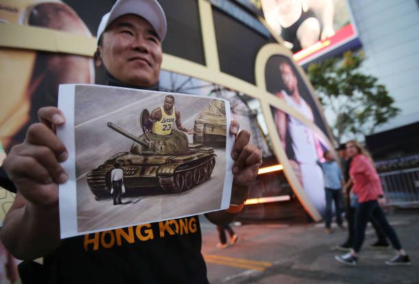 Pro-Hong Kong activist holds an image depicting LeBron James aboard a Chinese tank in Tiananmen Square before the Los Angeles Lakers season opening...