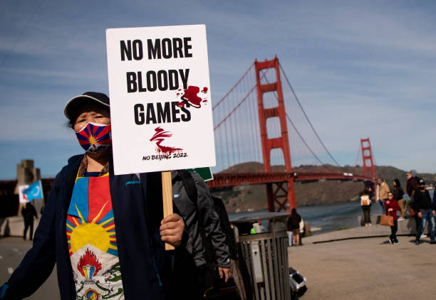 Protester holds up a "No More Bloody Games" sign while marching across the Golden Gate Bridge during a demonstration against the 2022 Beijing winter...