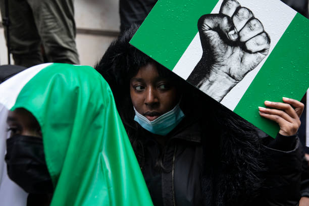 Protesters hold placards and signs calling for the end of police killings of the public in Nigeria, during a demonstration on October 21, 2020 in...