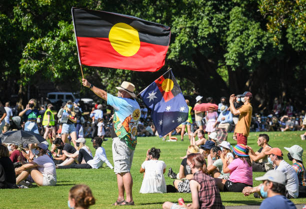 Protesters wearing face masks hold flags and banners as they prepare to march on January 26, 2021 in Sydney, Australia. Australia Day, formerly known...