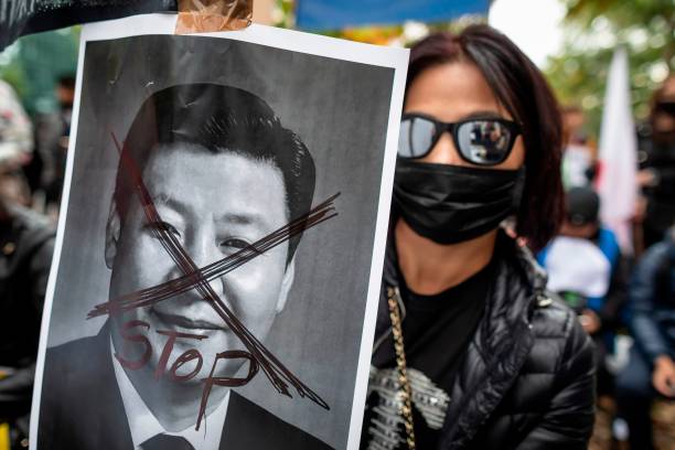 Protestor holds a portrait of Xi Jinping - General Secretary of the Communist Party of China as they demonstrate in front of China embassy in Warsaw...