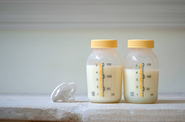 pumped breast milk - breast feeding bottle stock pictures, royalty-free photos & images