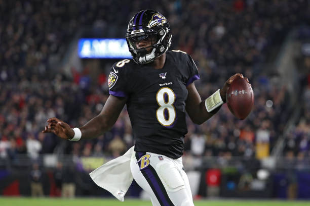 Quarterback Lamar Jackson of the Baltimore Ravens scores a first quarter touchdown against the New England Patriots at M&T Bank Stadium on November...
